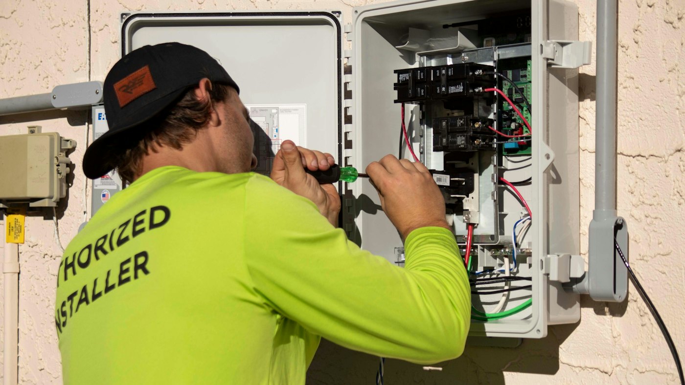 A technician working inside an electrical enclosure